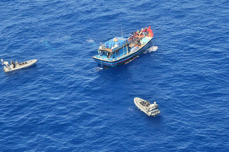 A Vietnamese illegal fishing vessel in the Coral Sea being intercepted by border force boats