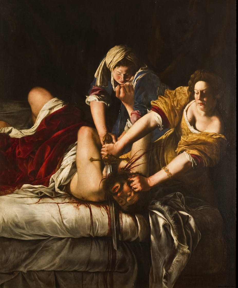 Two women pin down a man on a bed. With one hand, Judith holds his head; with the other, she slices his throat with a long sword.
