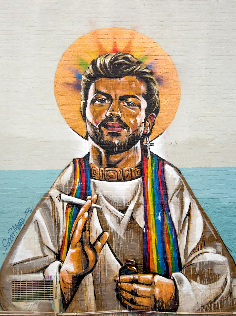 George Michael in priestly robes with a cross dangling from one ear, his head surrounded by a rainbow-coloured halo and smoking marijuana