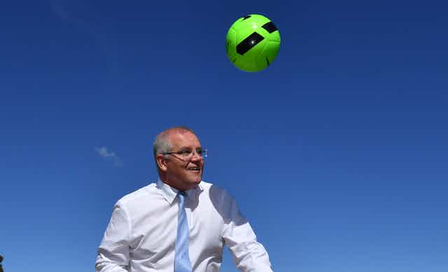 Australian prime minister Scott Morrison plays with a ball.