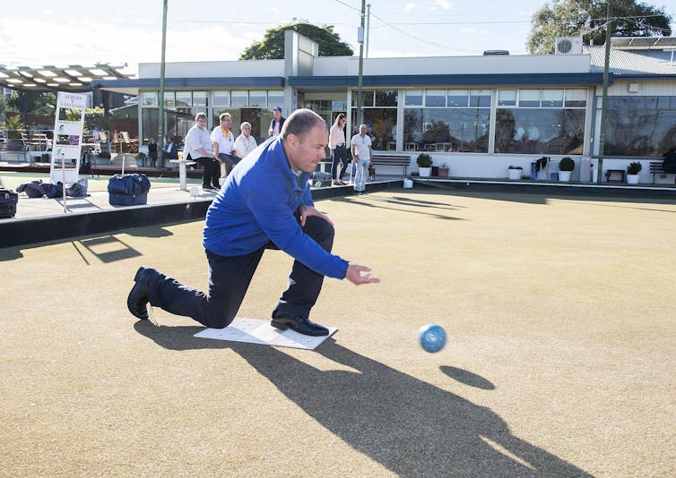 Treasurer Josh Frydenberg rolls a ball.