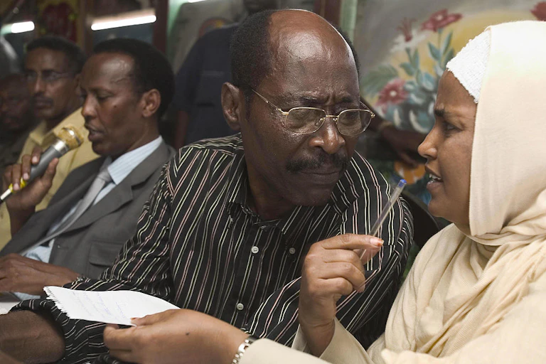 A file image in which the Somalia prime minister is seated with two of his ministers while addressing a group of elders who are out of view.