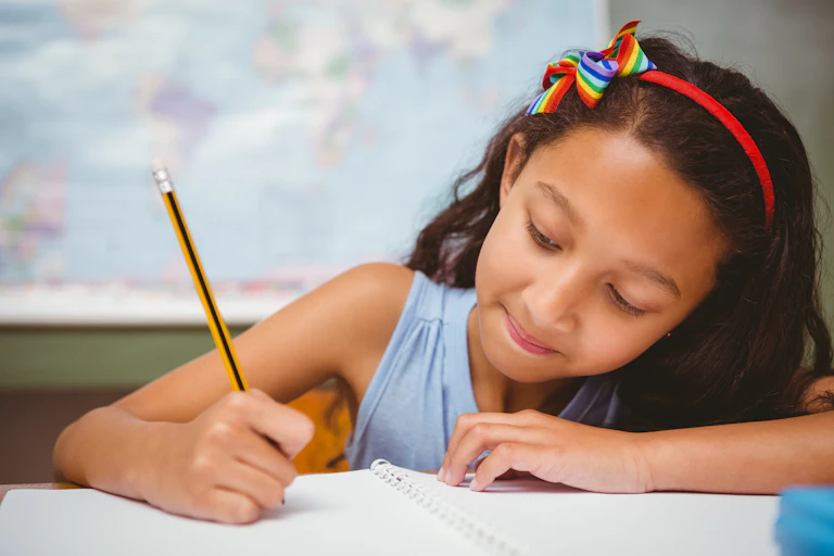 Girl writing in notebook with pencil