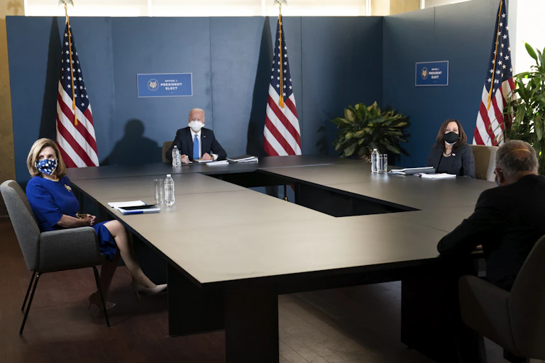Joe Biden, Kamala Harris, Chuck Schumer and Nancy Pelosi sit far apart at a table.