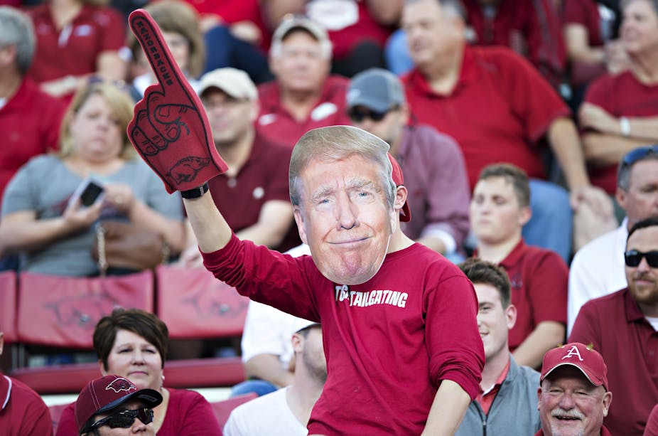An Arkansas Razorbacks fan wears a Trump mask.