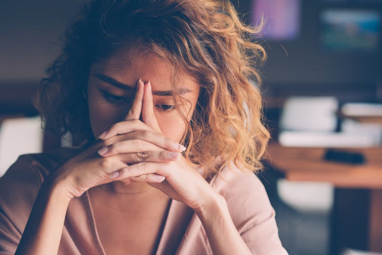 Young woman looking tired and stressed.