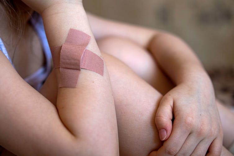 A girl with a bandage on her forearm.