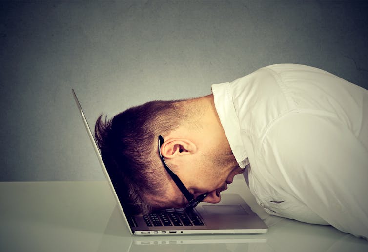 Man with his head in his computer.