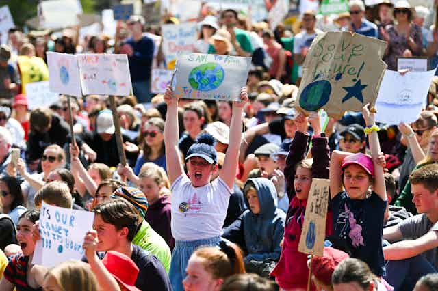 Young people holding up signs at a climate change protest