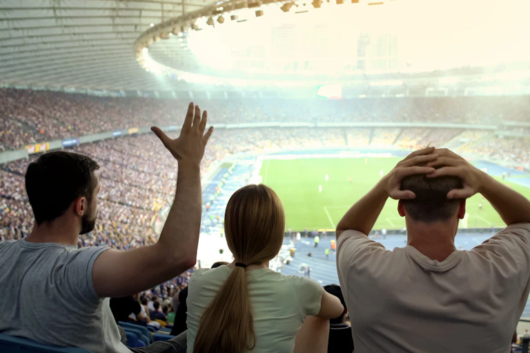 Three fans watching a football match.