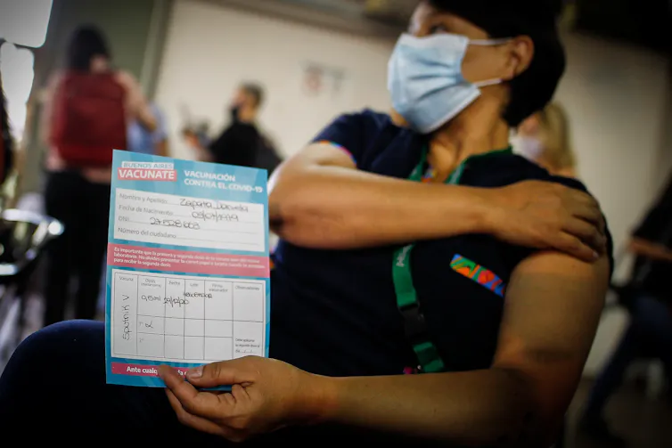 A woman showing a certificate confirming that she has been vaccinated with the Russian Sputnik V COVID-19 vaccine