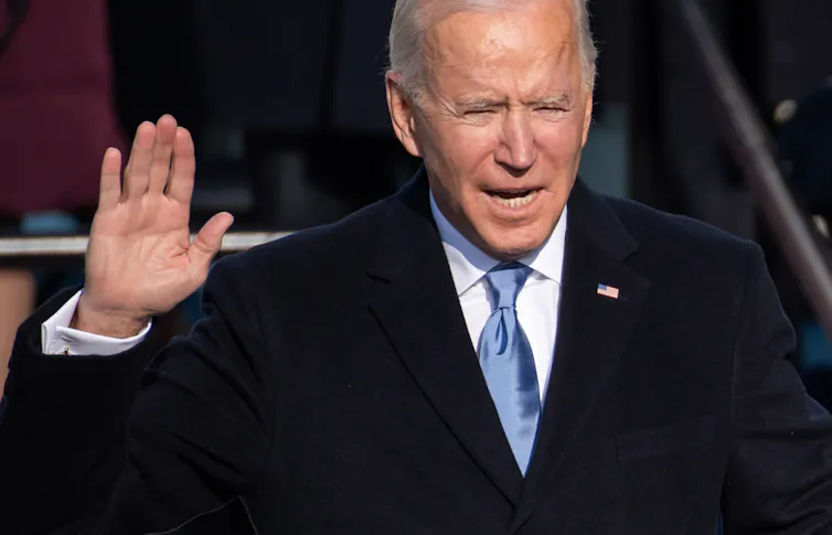 Joe Biden holds up his hand while swearing the Oath of Office during his inauguration on January 20, 2021.