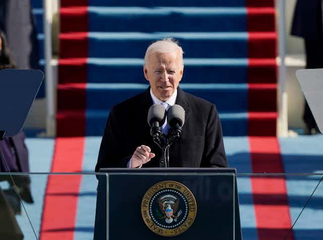 Joe Biden standing at a lectern outside the US Capitol to deliver his inaugural speech, January 20, 2021