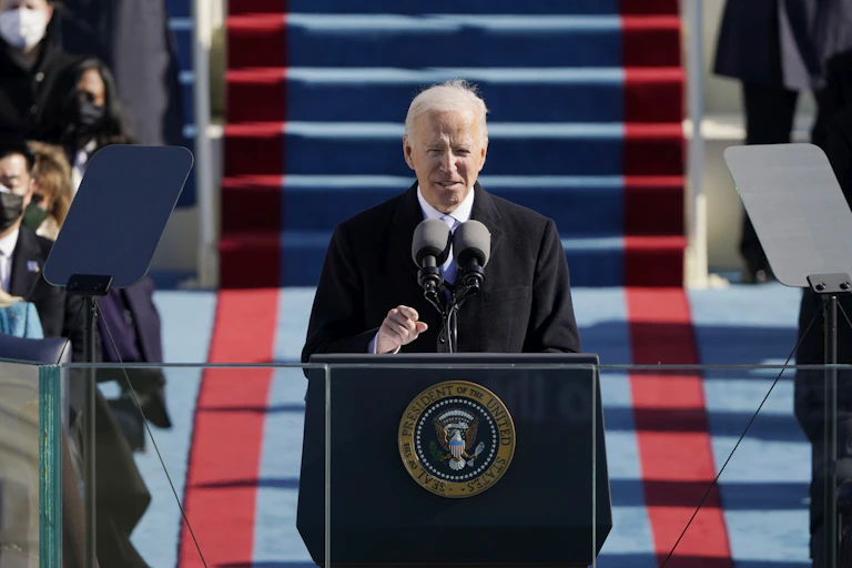 Joe Biden standing at a lectern outside the US Capitol to deliver his inaugural speech, January 20, 2021