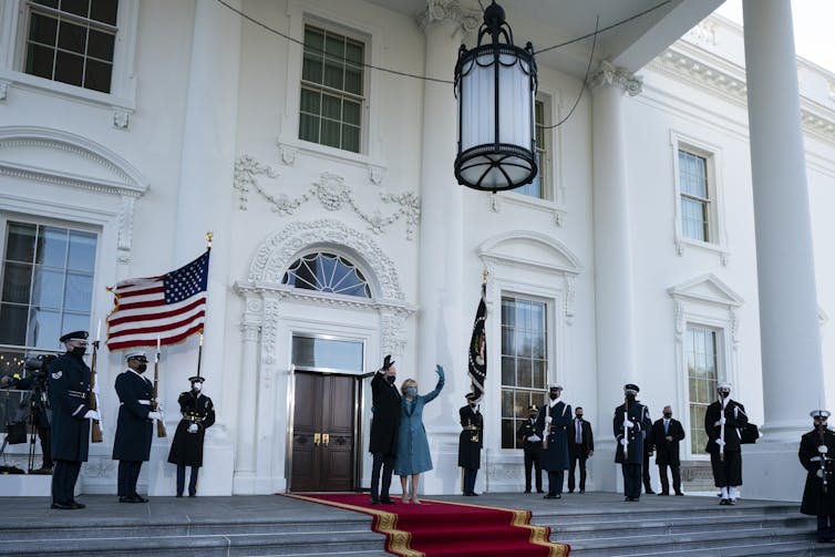 President Joe Biden and first lady Jill Biden wave as they arrive at the North Portico of the White House on Jan. 20.