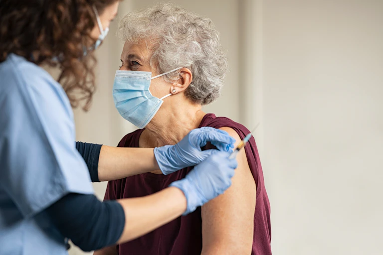Older woman getting a vaccine.