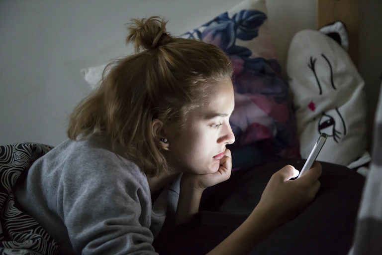 Teen girl in bed with mobile phone