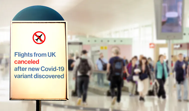 A sign at an airport saying flights from UK cancelled after new COVID-19 variant discovered,
