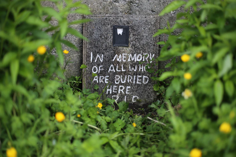 Crudely drawn memorial message on unmarked mass grave in Tuam.