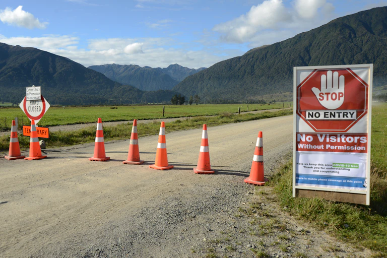 Traffic cones across a road urging people to stop due to COVID restrictions.