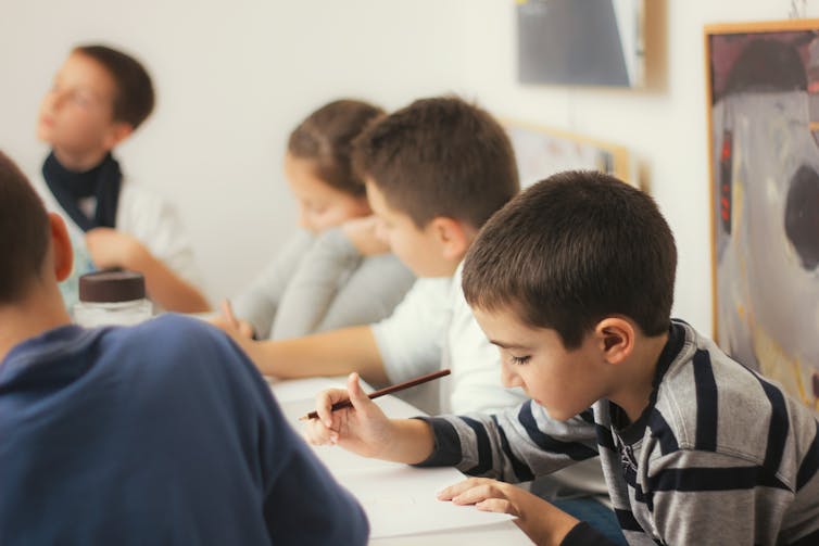 A group of five young kids learning.