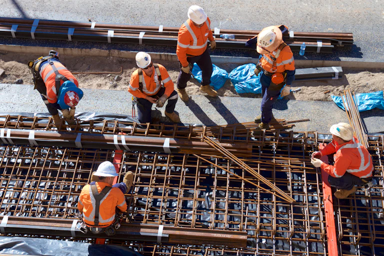 Construction workers work in the sun.