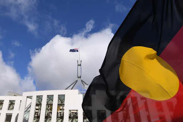 The Aboriginal flag flies in front of Federal Parliament