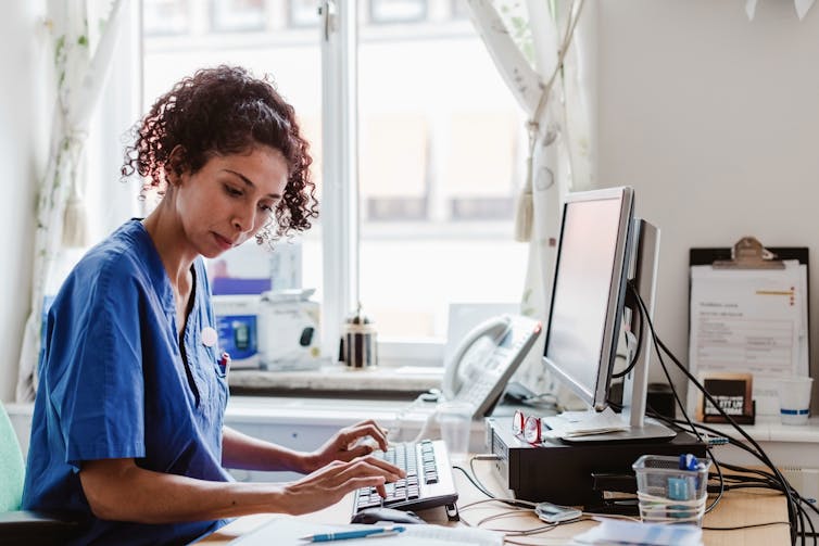 A nurse making a computerized medical report.