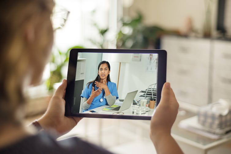 A patient talks to a doctor on her digital tablet.