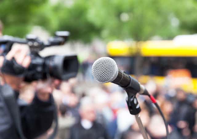 Microphone in focus against blurred crowd.