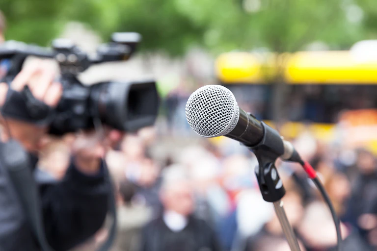 Microphone in focus against blurred crowd.