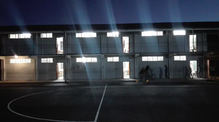 A lit up school building at night time.