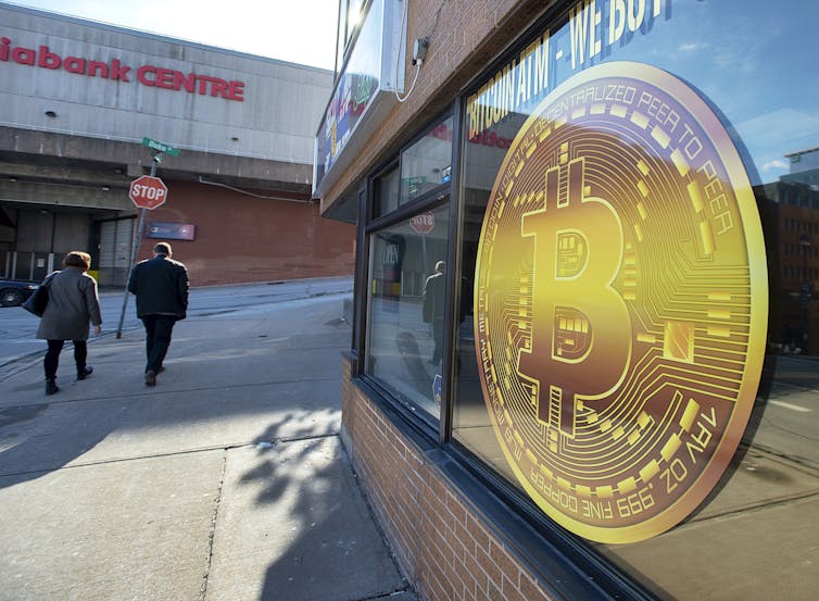 A sign advertises a Bitcoin ATM.