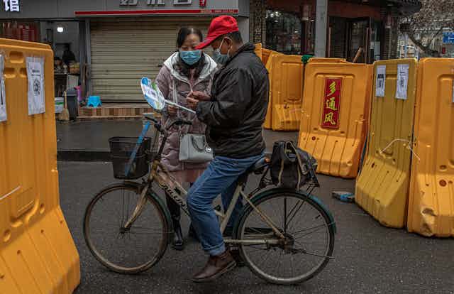 A checkpoint between two Wuhan neighbourhoods, where a health volunteer collections information from those passing through
