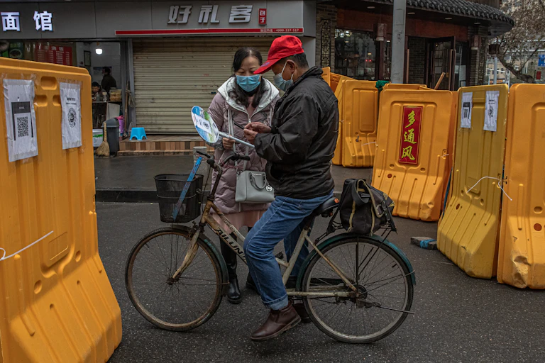 A checkpoint between two Wuhan neighbourhoods, where a health volunteer collections information from those passing through