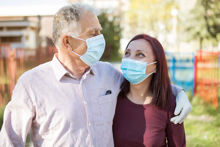 A couple in masks and gloves walking outside