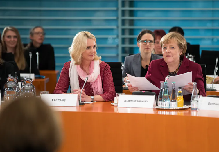 Angela Merkel and other women sit at a conference