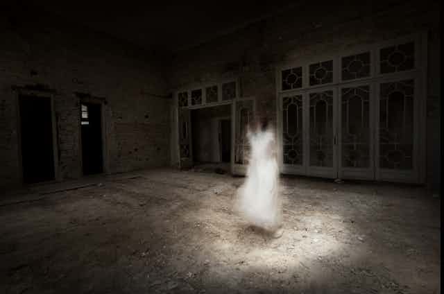 A ghostly figure of a girl in a dark room with rubble on the floor