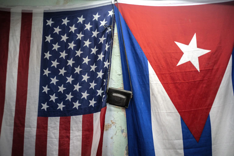 American and Cuban flags hang next to each other.