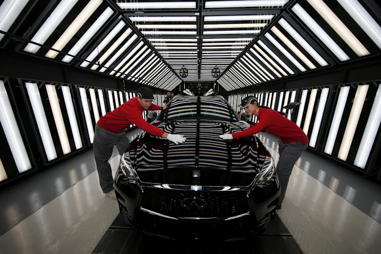 Two Nissan workers on the production line of the Infinity Q30