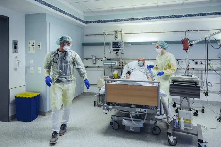 A doctor and nurse tend to a patient in the hospital.