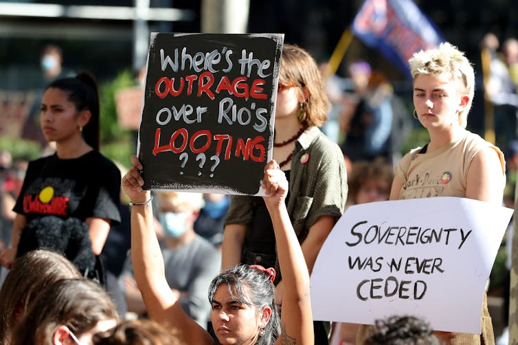 Protest signs against Rio Tinto destruction of ancient caves
