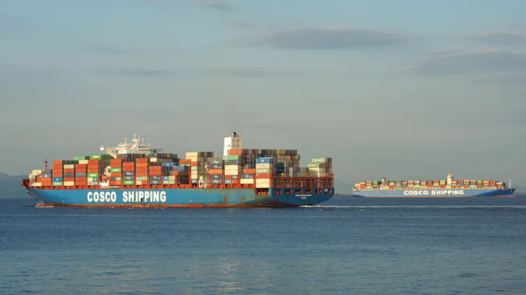 Container ship with COSCO SHIPPING written on hull, another ship in the distance