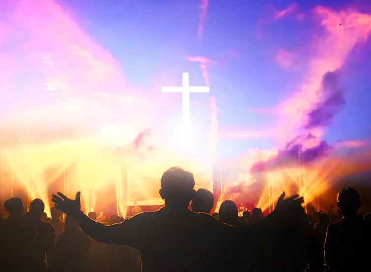 Colourful Christian chruch service with man holding arms out in prayer