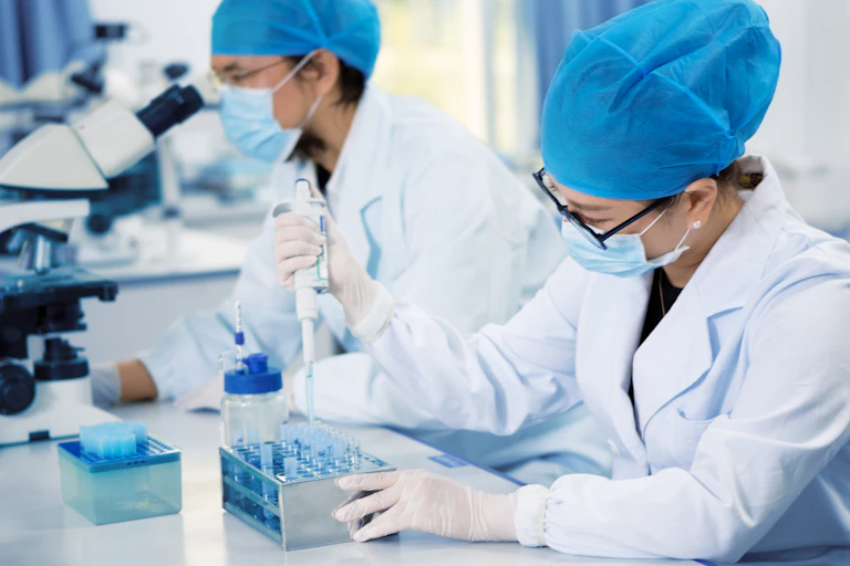 two women working in lab, seen through a door's window