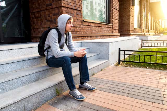 A youth sitting on steps.