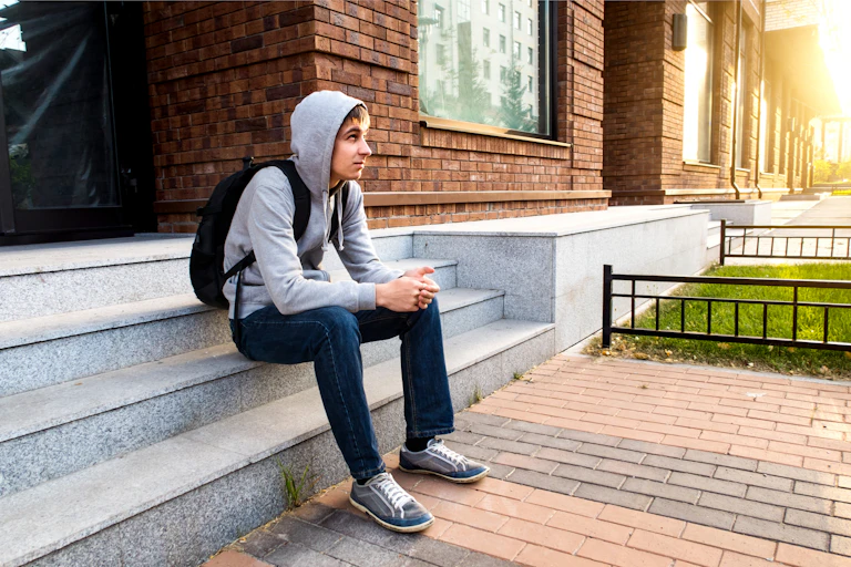A youth sitting on steps.