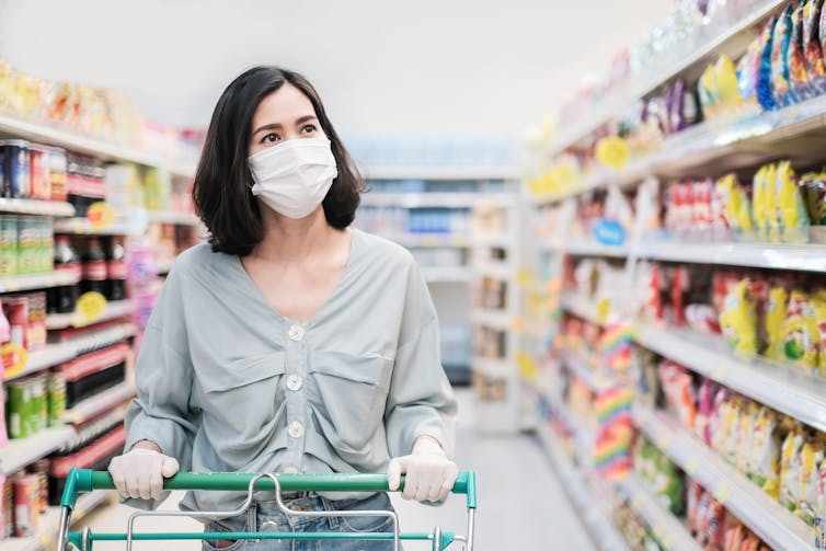 Women in supermarket wearing a facemask.