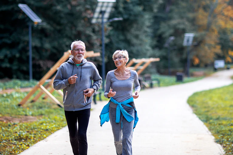 Older couple jogging in the park.