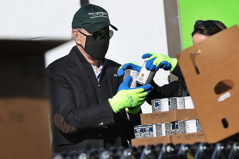 Joe Biden helps volunteers fill food donation boxes at the Philabundance food bank during the Martin Luther King National Day of Service on January 18, 2021 in Philadelphia, Pennsylvania.